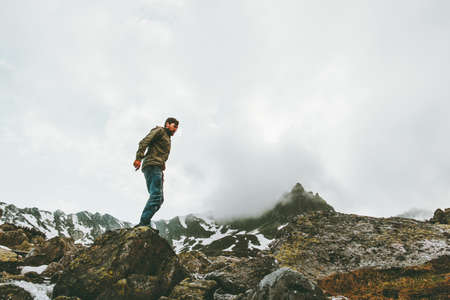 Traveler Man standing alone at foggy mountains Travel lifestyle survival emotional concept adventure outdoor active vacations wild nature の写真素材
