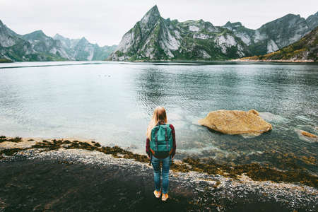 Tourist woman walking at fjord rocks Lofoten islands in Norway Travel lifestyle concept adventure outdoor summer vacations scandinavian nature の写真素材