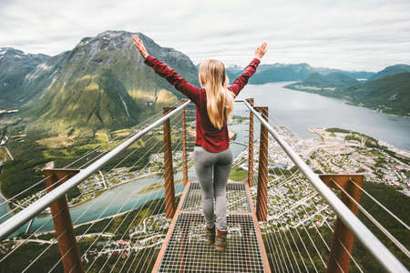Young woman enjoying aerial mountains view Travel Lifestyle adventure vacations success emotions in Norway girl walking alone on Rampestreken の写真素材