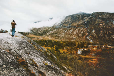 Man traveler standing alone on cliff foggy forest mountains landscape Traveling adventure lifestyle concept scandinavian vacations in Norwayの写真素材
