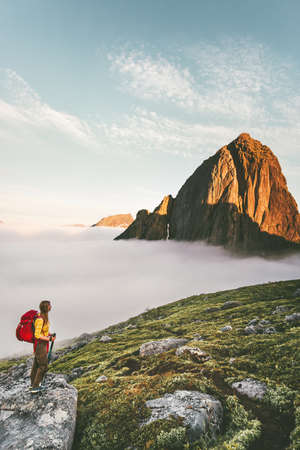 Lost in mountains traveler exploring alone hiking with backpack adventure traveling lifestyle weekend getaway summer vacations midnight sun in Norwayの写真素材