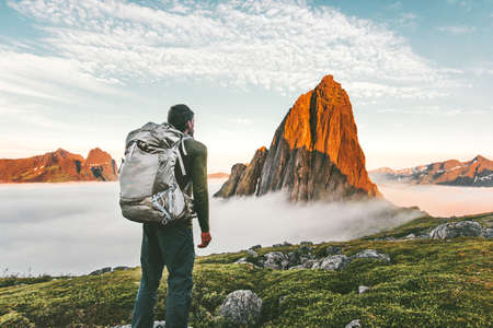 Backpacker man exploring sunset rocky mountains alone hiking adventure journey summer vacations traveling lifestyle weekend getawayの写真素材