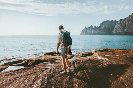 Man traveler walking alone on beach traveling vacations in Norway lifestyle outdoor Okshornan peaks landscapeの写真素材