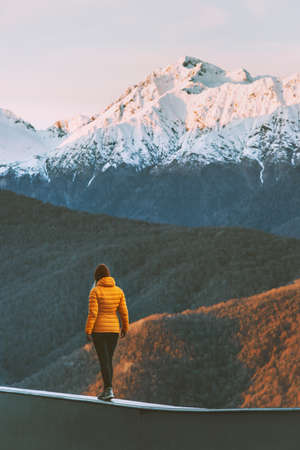 Woman walking alone in sunset mountains active lifestyle winter vacations outdoor hiking adventure solitude and silenceの写真素材