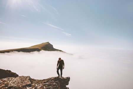 Tourist man exploring mountains over clouds active adventure solo traveling lifestyle summer vacations outdoor の写真素材