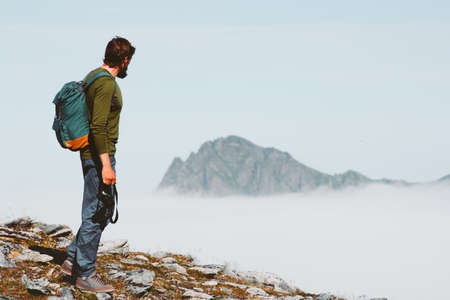 Man solo traveling in mountains adventure vacations freedom lifestyle outdoor with backpack and photo cameraの写真素材