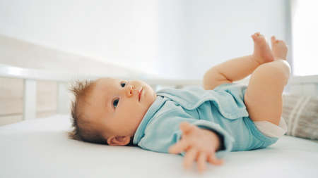 Infant girl lying on bed at home adorable 2 month old baby kid の写真素材
