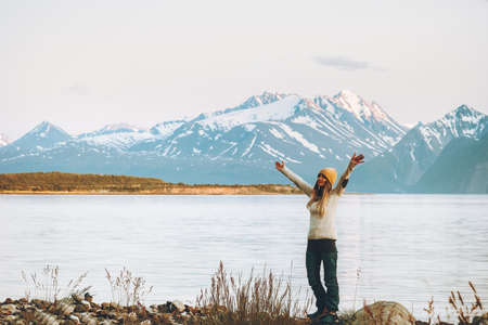 Woman adventurer raised hands enjoying mountains view travel adventure vacations in Norway harmony with natureの写真素材