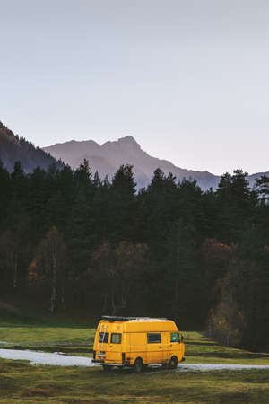 Travel van yellow camper road trip vacations in mountains summer family journey vanlife weekend caravan campingの写真素材