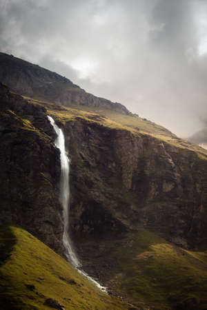 Waterfall in a valley between mountains in the french alpsの写真素材