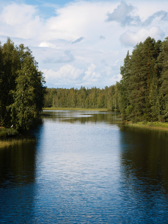 Idyllic waterways connecting the lakes of Finland between lush green forestsの写真素材