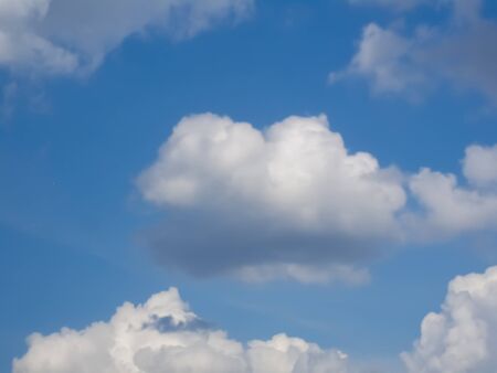 White puffy cumulus clouds in blue skyの写真素材