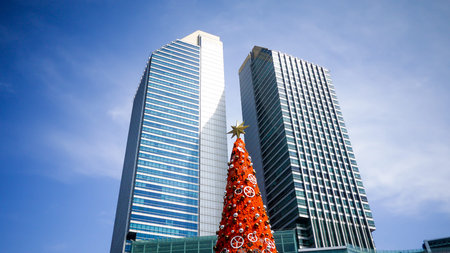 Beautiful decorated christmas tree with star and sparkle ball with 2 big buildings background.の写真素材
