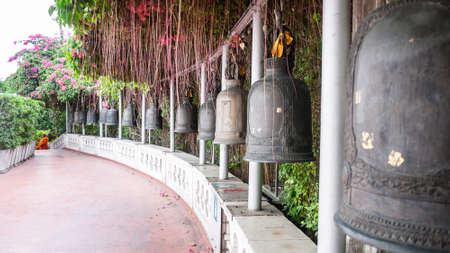 Bangkok, Thailand - Jan 25, 2016: Old bells for people to ring to make a wish and respect the temple in golden mount temple, bougainvillea and ivy cover .のeditorial素材