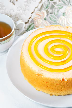 Sponge orange cake dessert with tea on tableの写真素材