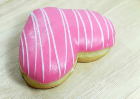 Donut in love heart shape on wooden tableの写真素材
