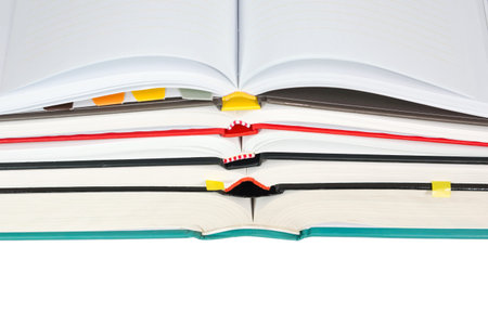 Stack of open books with notebook on top isolated on white background