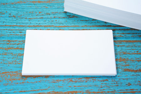 Blank business card on blue wood desk