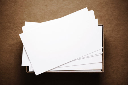 Business cards in box on dark brown cardboard background