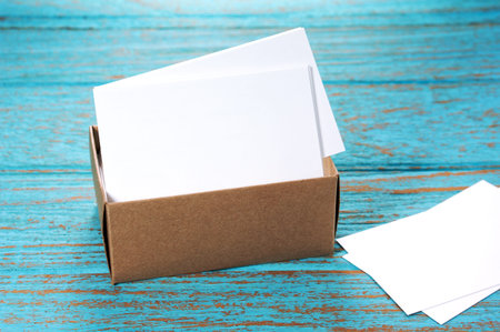 Business cards in brown paper box on wood desk