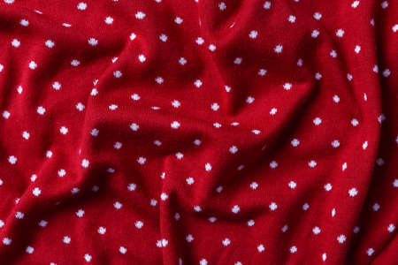 Red knit fabric with polka dot texture backgroundの写真素材