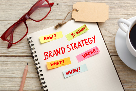 Brand marketing strategy concept with notebook, brand tag and eye glasses on office deskの写真素材