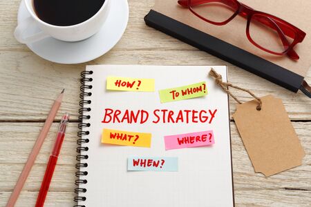 Brand marketing strategy concept with notebook, brand tag and coffee cup on office deskの写真素材