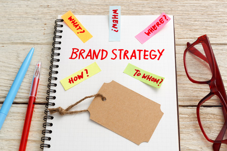 Brand marketing strategy concept with kraft tag and eye glasses on office deskの写真素材