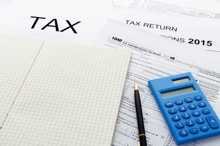 Tax return form 2015 with blank notebook and calculator