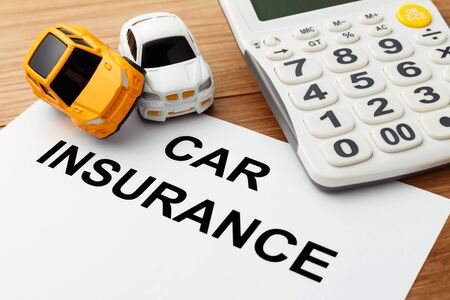 Car insurance concept with calculator on wood tableの写真素材