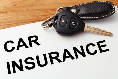 Car insurance concept with car key on wood tableの写真素材