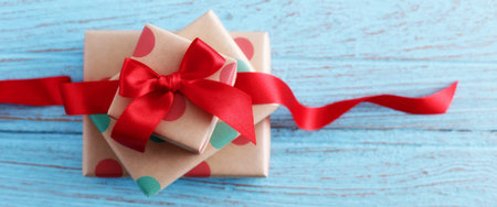Presents for birthday with red bow and ribbon on wood table