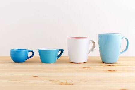 Mugs and cups in blue and white on wood tableの写真素材