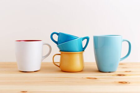 Cups and mugs on wooden kitchen tableの写真素材