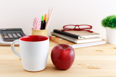 White coffee mug mockup with red apple on wooden tableの写真素材