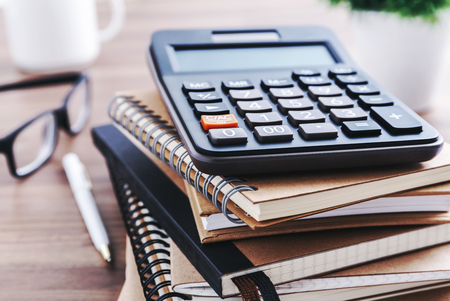 Calculator with notebook and pen on office deskの写真素材