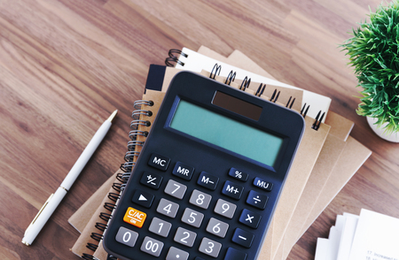 Calculator with notebook and pen on office desk backgroundの写真素材