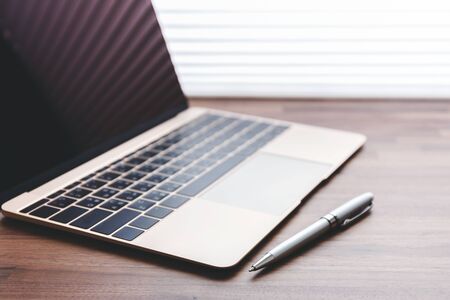 Laptop with pen on office tableの写真素材