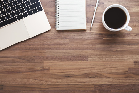 Office wood desk background with laptop and coffee cup flat layの写真素材