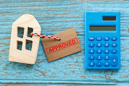 Wood house and calculator with approved label for housing loan conceptの写真素材