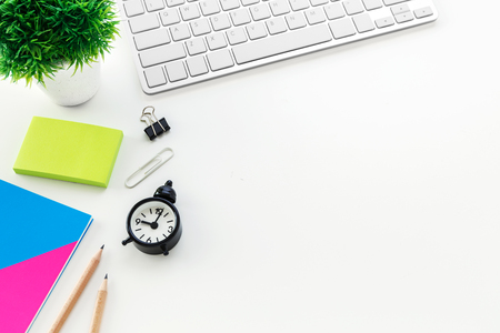 Modern office desk with computer blank notepad pencil clock with copy spaceの写真素材