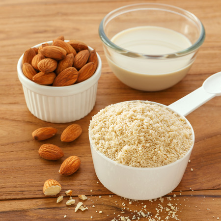 Almond flour and milk with almonds on wooden table backgroundの写真素材