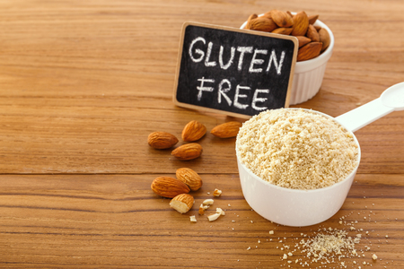 Almond flour with almonds and gluten free sign on wooden table backgroundの写真素材