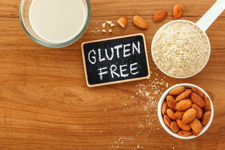 Almond flour and milk with almonds and gluten free sign on wooden table background top viewの写真素材