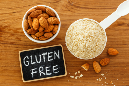 Almond flour with almonds and gluten free sign on wooden table top viewの写真素材