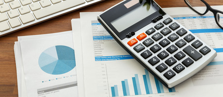 Financial accounting with calculator and financial chart  data on wooden tableの写真素材