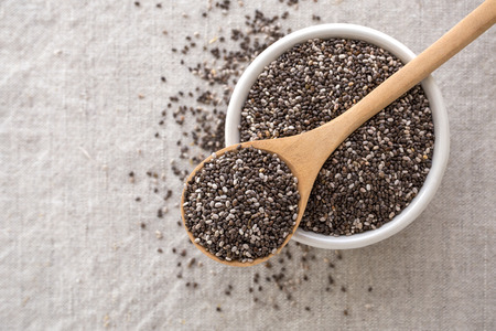 Chia seeds in wooden spoon and bowl from top view with spaceの写真素材