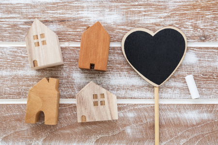 House model with heart sign on wooden table background from top viewの写真素材