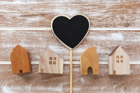 House model with heart sign on wooden table background from top viewの写真素材