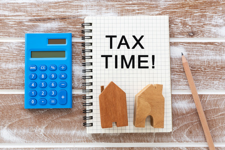 House model with calculator on wooden table background property tax conceptの写真素材